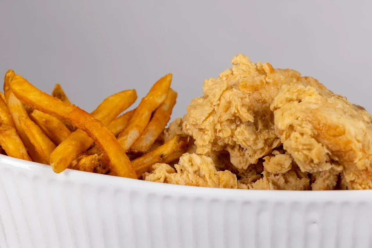 Golden fried chicken and seasoned fries, up close