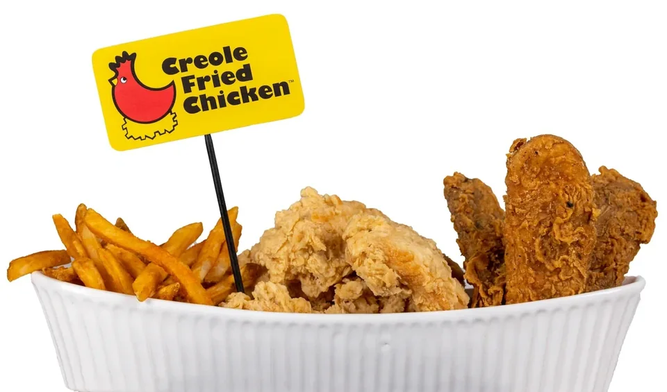 A bowl of Creole Fried Chicken and fries with the brand sign